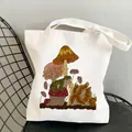 Cream canvas tote bag with vintage frog and mushroom forest illustration on a black chair - C5-Frog & Mushroom Landscape (No Zipper No Pocket)