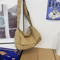 Minimalist khaki canvas crossbody bag hanging in a natural indoor setting - Khaki