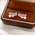 Macro shot of silver stud earrings with graduated pearls and white zircon on velvet - Silver-White Pearl