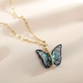 Macro shot of gradient blue butterfly pendant necklace with golden chain on satin - Chain Necklace Gradient Blue Gold
