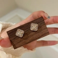 Golden clover earrings with pearls and pink gems shown on a wooden display card - Ring - Gold