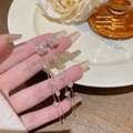 Elegant gold tassel earrings with sparkling zircons shown held in hand lifestyle shot - Gold Simple Tassel (E0304)