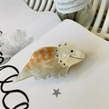 Detail of cute acrylic dinosaur hair claw clip in beige and orange with smooth texture - Light Khaki Triceratops