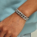 Bracciale cubano argento hip-hop con strass luccicanti al polso di un modello maschile - Argento