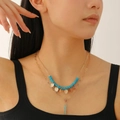Collana a doppio strato con perline blu cielo e ciondoli dorati indossata da modella - Stile a Doppio Strato con Perline Celeste (5647)
