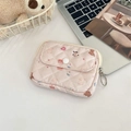 Detailed view of pink quilted bag with cute cartoon bear and rabbit patterns on a desk - Donut Bear