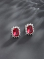 Macro shot of rectangular ruby earrings with white zircon halo on grey texture - Stud Earrings / White Plated Ruby Red