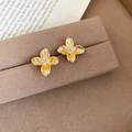 Macro detail of gold flower earrings with marquise-cut zircons on a velvet jewelry box - Gold