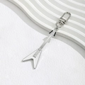 Creative white and silver guitar keychain with metal D-ring clasp on a textured surface - White