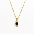 Detailed close-up of golden owl pendant with a black gem and micro-pave crystals - With Necklace / Black