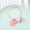 Dettaglio di un portachiavi a fiore rosa con campanellino e anello su piatto verde - Anello in Filo + Fiore Morbido + Campanello da 22mm / Rosa
