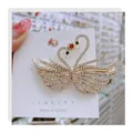 Golden swan brooch pin with white crystals and red gemstone eye on display card - Swan Hair Clip