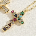 Dettaglio macro della collana con ciondolo a croce dorata e pietre di zircone colorate - Croce in Zirconia Irregolare