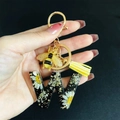 Detail of resin letter W keychain with white daisy flowers, gold flakes and bee charm - Letter W