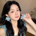 Light blue fabric flower earrings with delicate white pearl tassels on a female model - Mint Green Flower Tassel