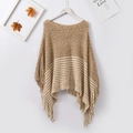 Detailed close-up of brown and beige striped knit poncho with long decorative fringe tassels - Khaki