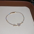 Detailaufnahme eines funkelnden Zirkonia-Blumenarmbands auf einem weißen Display - Goldene Blumen-Stern-Zirkonia-Tennis-Kette (47#) / Gold