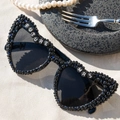 Detail of black heart sunglasses with Future Mrs letter beads and pearls on sand - Future Mrs