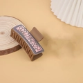 Brown hair claw clip with metallic sunflower pattern detail on a wooden base - Brown / Sunflower Pattern
