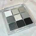 Macro view of 9-color eyeshadow palette with matte grey, black and silver glitter shades - No. 07 Black White Grey Gradient