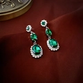 Nahaufnahme der smaragdgrünen ovalen Ohrringe mit Kristallkranz auf roter Seide - Silbernadel Grüne Strass Oval Ohrstecker
