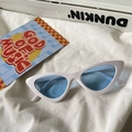 Close-up of retro cat-eye sunglasses with white frame and light blue lenses on fabric - Cat Eye / White Frame Blue Lens