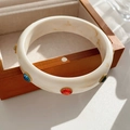 Close-up of cream marbled acrylic bracelet with colorful rhinestones on wood box - White with Multicolored Stones