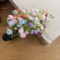 Detail von buntem Acryl-Haarclip mit mehrfarbigen Mini-Blüten auf einem Buch präsentiert - Entenschnabel-Clip - Grün - Mehrfarbig