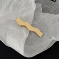 Dettaglio del fermaglio per capelli ondulato in metallo dorato con finitura lucida - Stile Bordo a Onda Oro