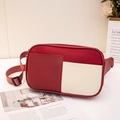 Red and white patchwork nylon waist bag with adjustable strap on a minimalist desk - Red