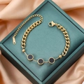 Bracciale minimalista in acciaio al titanio dorato con tre ciondoli neri su scatola di seta - Oro Nero