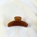 Dettaglio di una grande molletta per capelli leopardata in acetato lucido su tessuto - Marrone