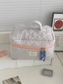 Detailed macro shot of pink and blue checkered makeup bag with diamond quilting and handle - Makeup Bag / Pink