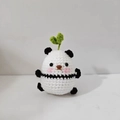 Handgefertigte Panda-Strickpuppe in Schwarz-Weiß mit grünem Spross und rosa Wangen - Panda