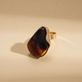 Detail eines Vintage-Goldrings mit einem tropfenförmigen braunen Bernstein-Harzstein - Braun