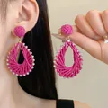 Gros plan de boucles d'oreilles goutte en raphia fuchsia avec strass et perles tissées - 5# Tige en Acier - Goutte d'Eau Strass Rose