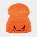 Close-up of orange Halloween beanie with black embroidered monster face and knit texture - Orange