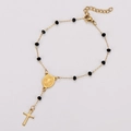 Macro detail of gold stainless steel religious bracelet with black beads and a cross pendant - Gold Black