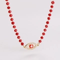 Detailansicht der roten Perlenkette mit einem goldfarbenen Evil Eye Anhänger und Kristallen - Rot