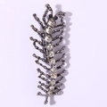Close-up of a centipede-shaped brooch with dark grey metal and inlaid crystal rhinestones - White