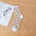 Beige sheer ankle socks with white bow pattern on a professional flat lay background - White Bow