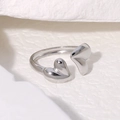 Polierter silberner Herzring mit asymmetrischem Doppelherz-Design auf weißem Sockel - Silber