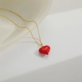 Detailed close-up of a gold necklace chain with a glossy red heart pendant on white fabric - Medium Red Heart (XL3425-2)