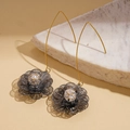 Detail of 18K gold-plated hollow flower earrings with zircon crystal on marble background - Silver