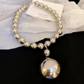 Dettaglio collana a sfere argentate con grande ciondolo a sfera a specchio su carta bianca - Argento