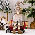 Weihnachtswichtel mit gestreiften Beinen und brauner Strickmütze auf einem roten Spielzeugauto - Gestreifter Hängebein-Zwerg / Braun