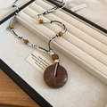 Dettaglio macro del ciondolo retrò in legno e resina su collana in corda fatta a mano - Stile Tondo Caffè