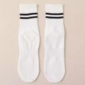 White crew yoga socks with black stripes and anti-slip grips on beige background - One Size / White