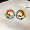 Close-up of bohemian multi-color handmade beaded rings with elastic bands on a tray - Multi-color (925 Sterling Silver Pin)
