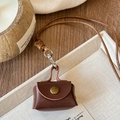 Close-up of a mini dark brown leather pouch charm with metal clasp on a beige tray - Necklace-Coffee Mini Bag